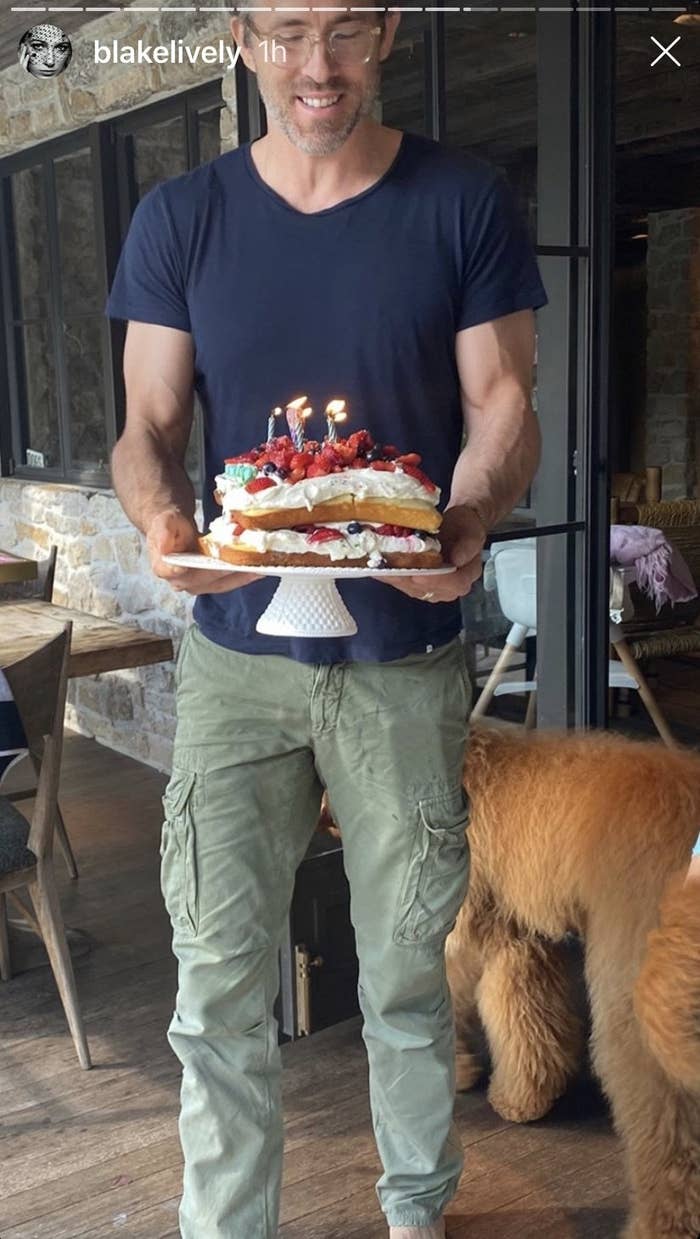 Ryan Reynolds holding a birthday cake for Blake Lively