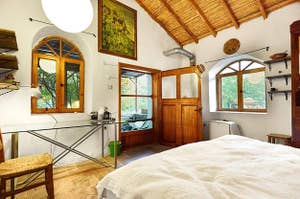 light-filled cottage bedroom with arched windows and wooden accents