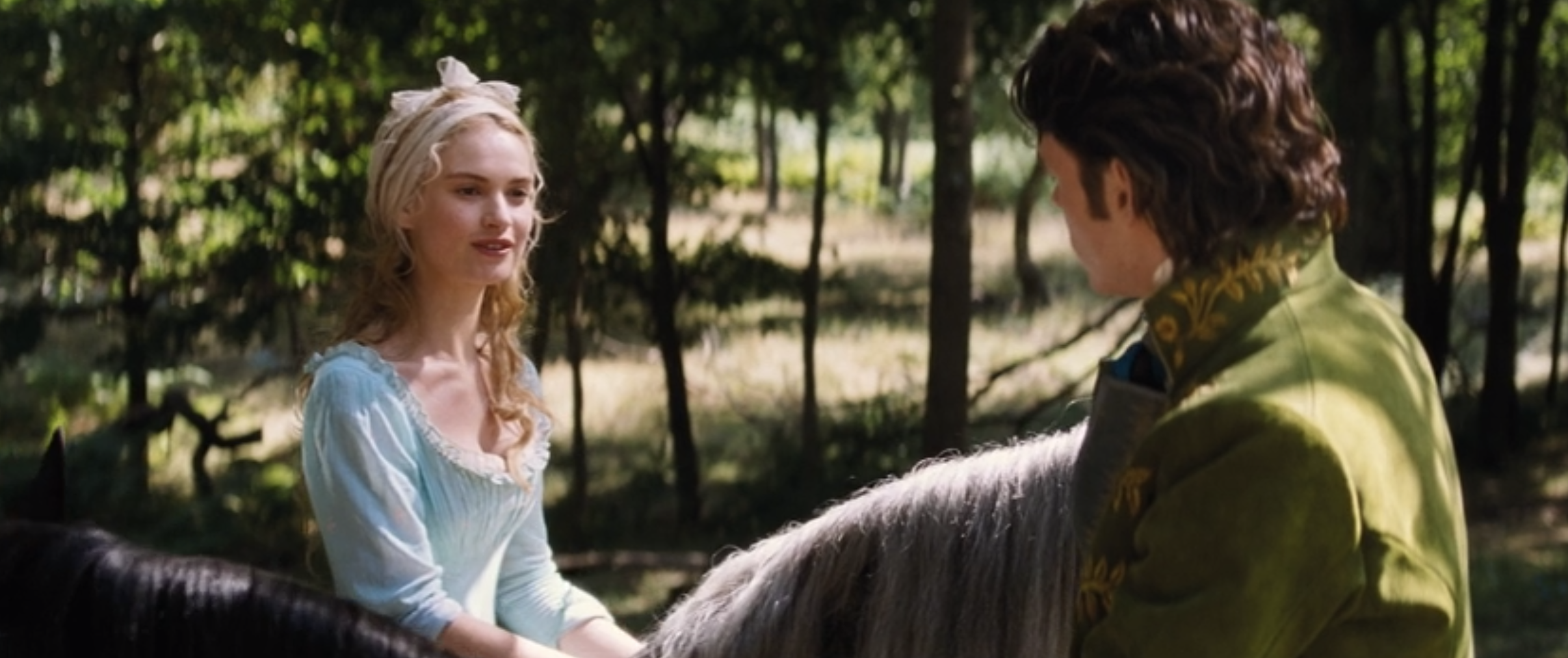 Lily James as Ella and Richard Madden as Kit crossing paths with each other on horseback in the live-action &quot;Cinderella&quot;
