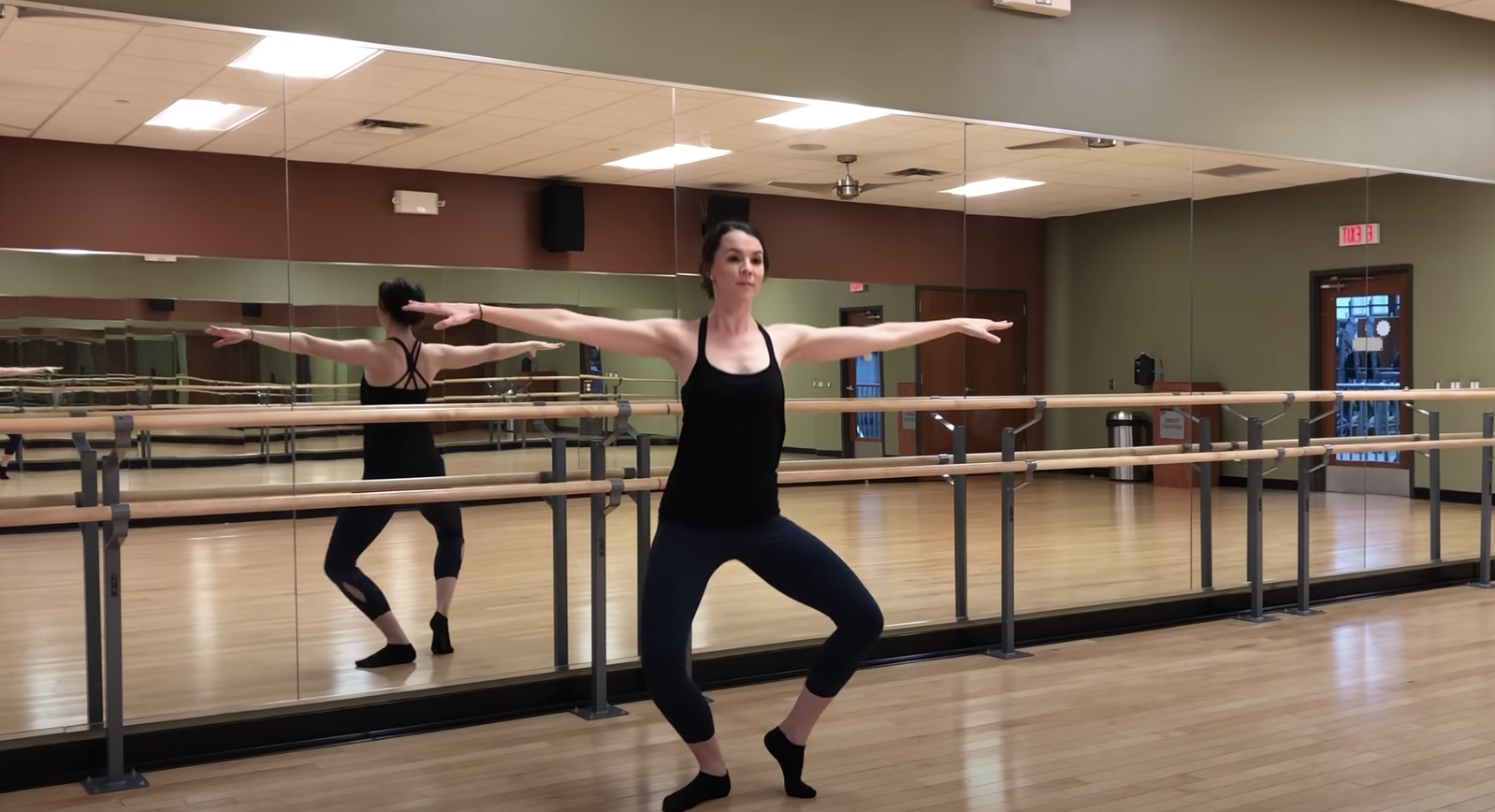 YouTuber Coach Kel doing a barre exercise