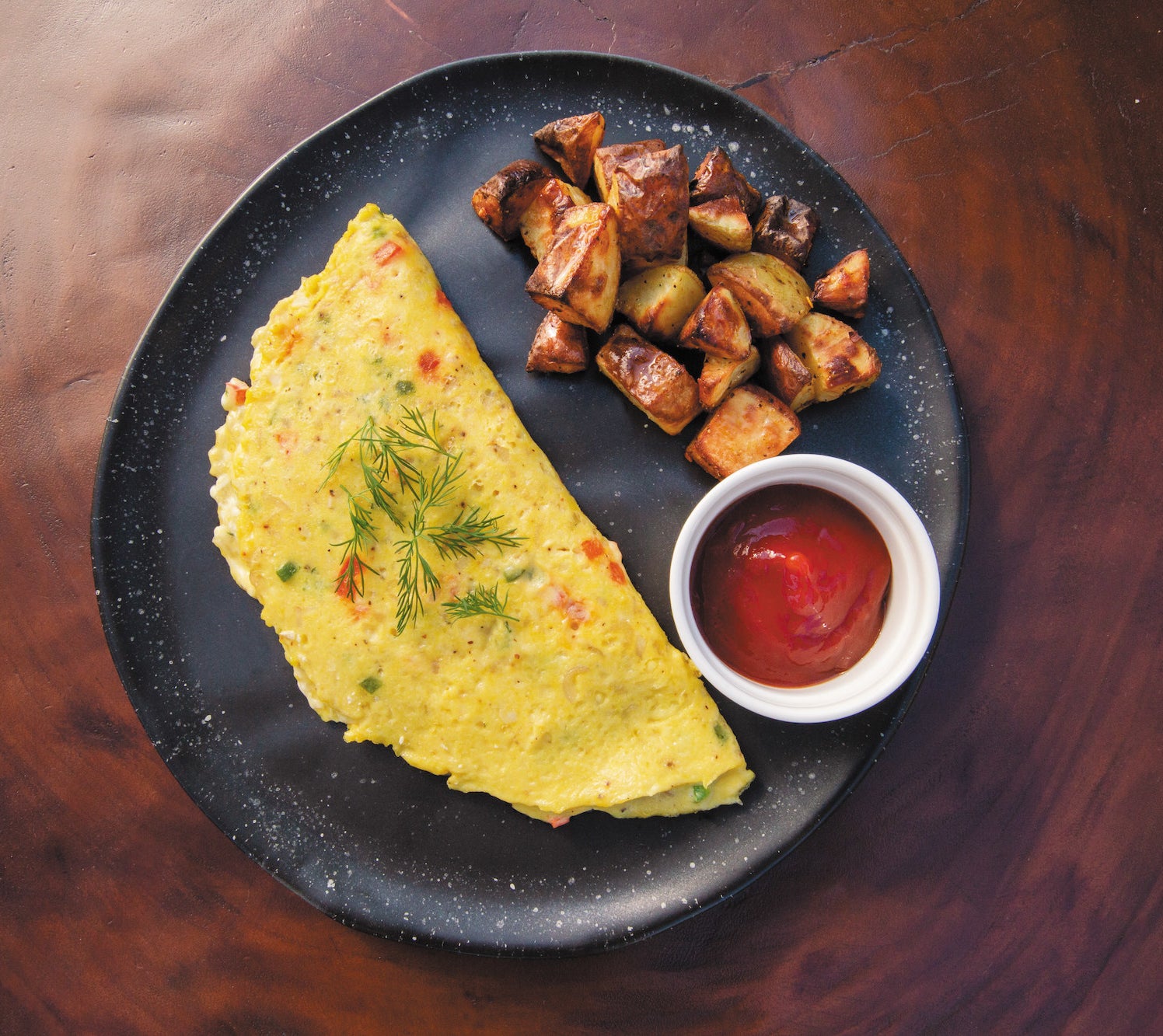 An egg-free omelet with a side of potatoes with ketchup on the side.