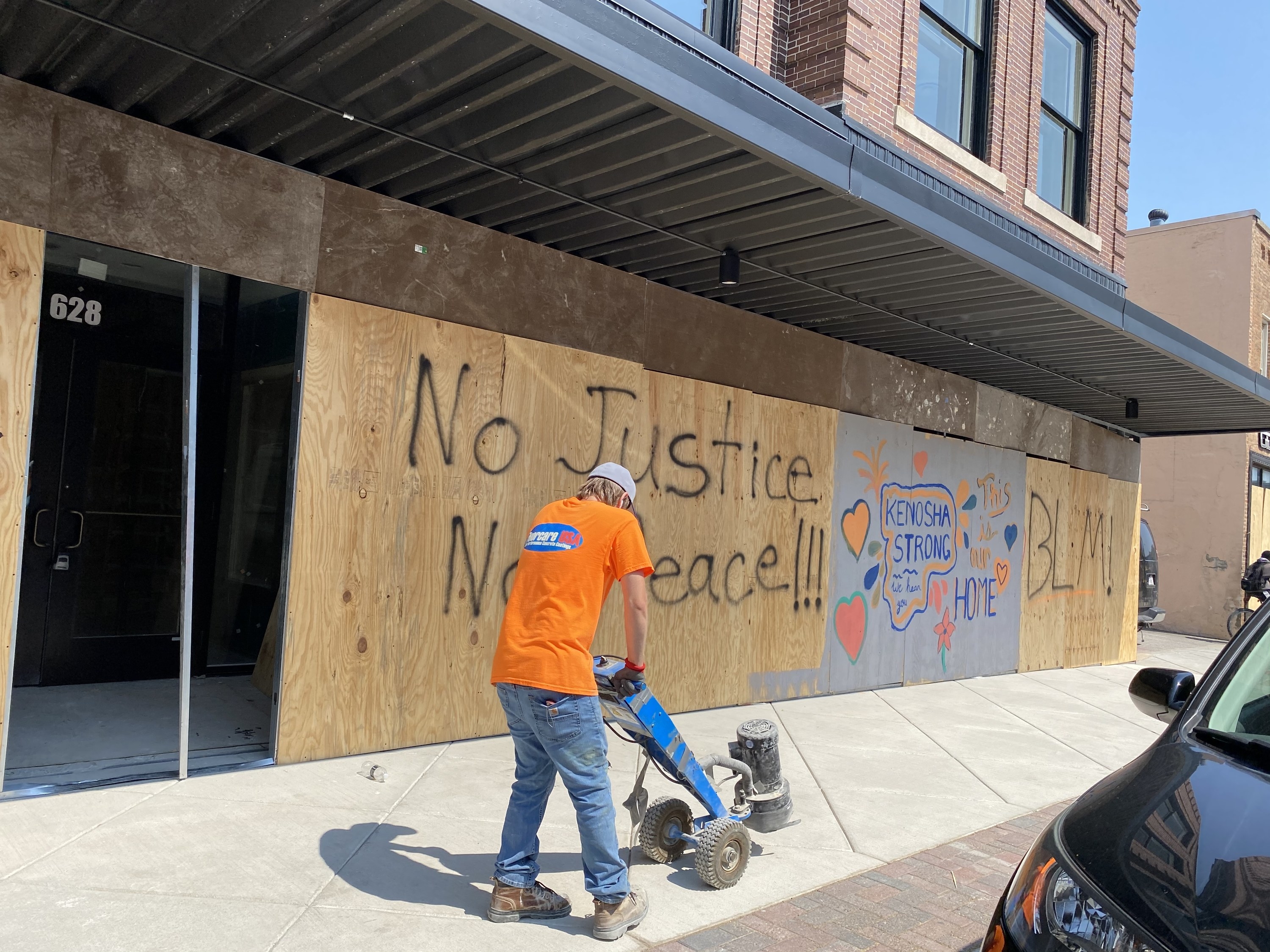 A wall has &quot;No justice, no peace,&quot; &quot;Kenosha strong,&quot; and &quot;BLM&quot; written on it