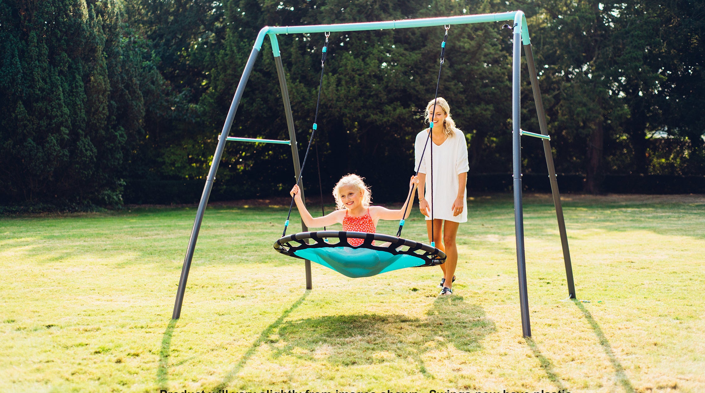 a mother pushing a girl in a metal nest swing