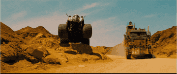A huge monster truck leaping on a desert path.
