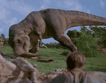 A T-Rex shaking a raptor.