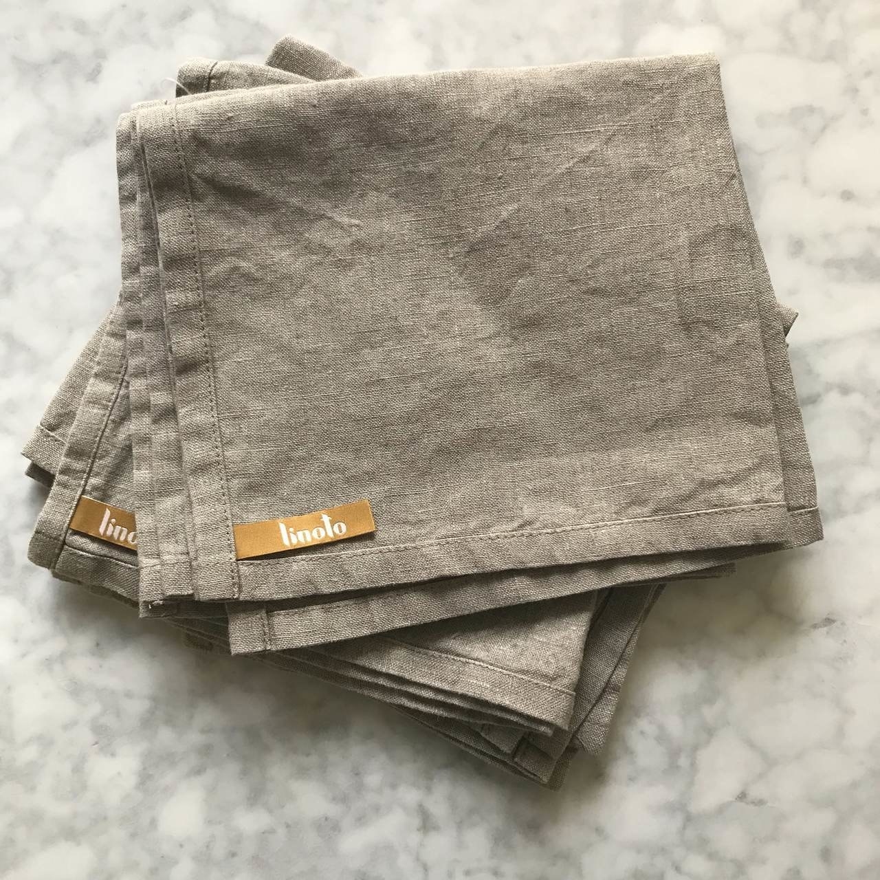 several folded tan linen towels with linoto labels