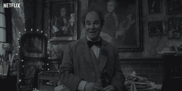 A gif of a person with a bowtie saying &quot;Upgraded&quot; enthusiastically 