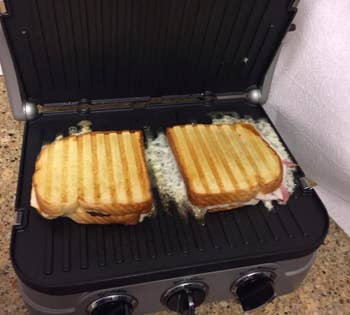 A reviewer making two paninis on the griddler