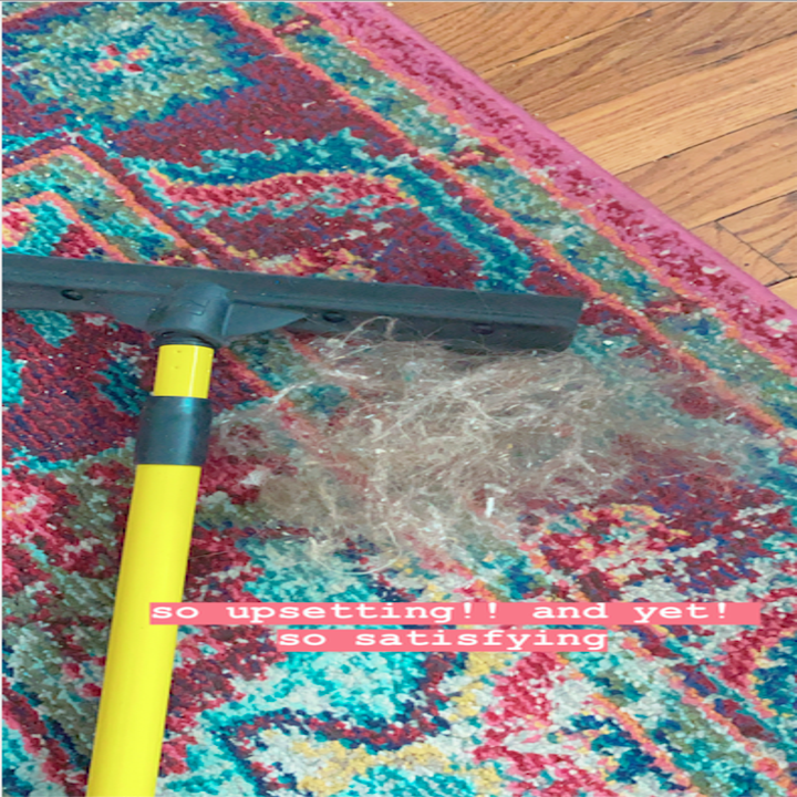 BuzzFeed Shopping reviewer's carpet with a hairball next to the broom 