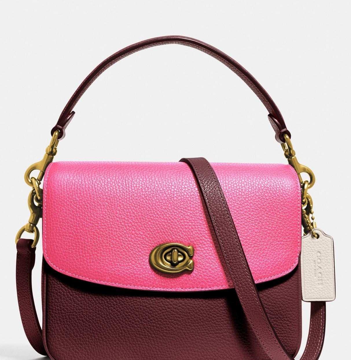 Maroon crossbody with hot pink flap and burnished gold metal handle hooks and clasp