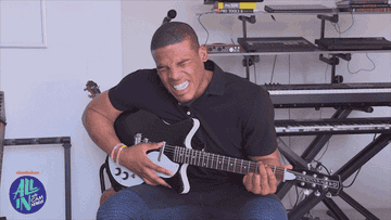A man dramatically pretends to play guitar