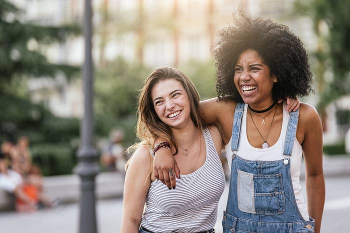 Two women smiling in the street