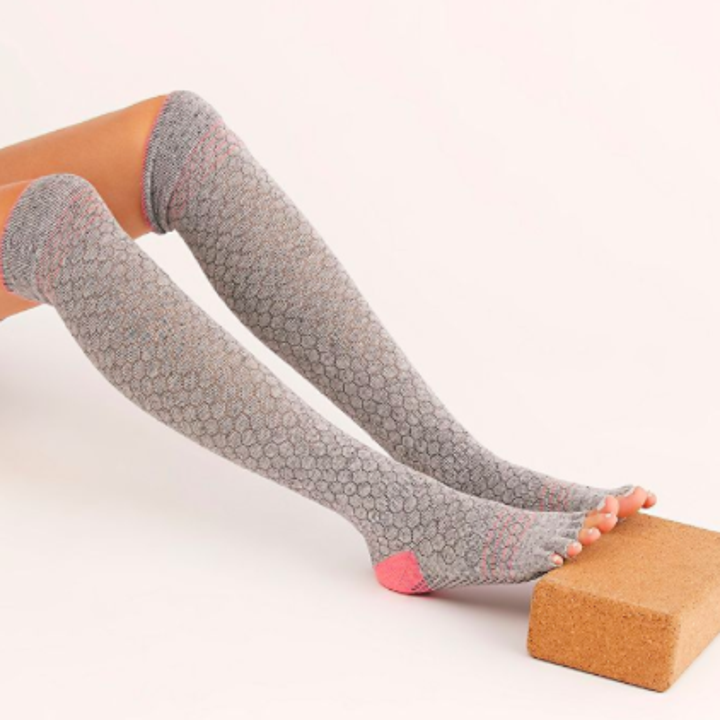 A close up of a person's legs wearing the grip socks while seated