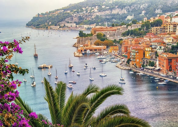 Boats coming into the harbour and pretty buildings on the coastline