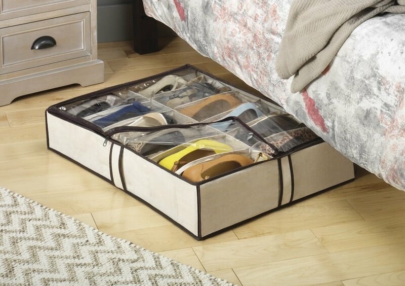 A white, under-bed shoe bag with a clear cover holding 12 pairs of shoes