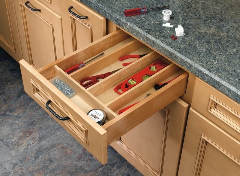 A wooden kitchen utensil organizer holding a variety of tools