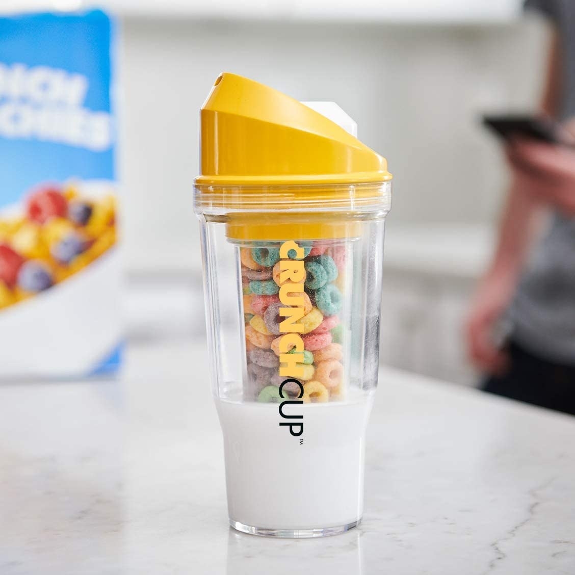 A cereal cup filled with milk and cereal on a kitchen counter