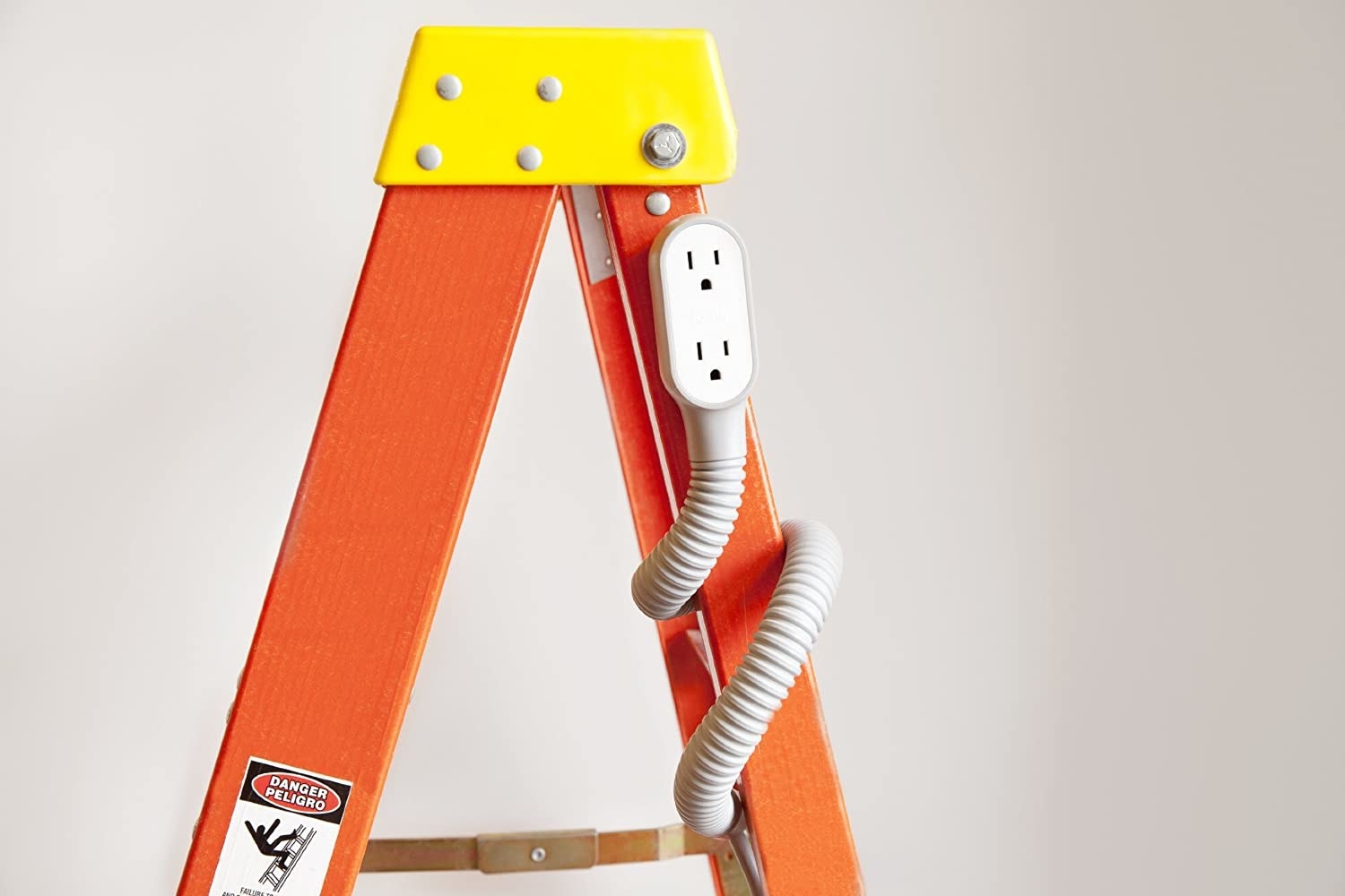 The extension cord wrapped around a ladder