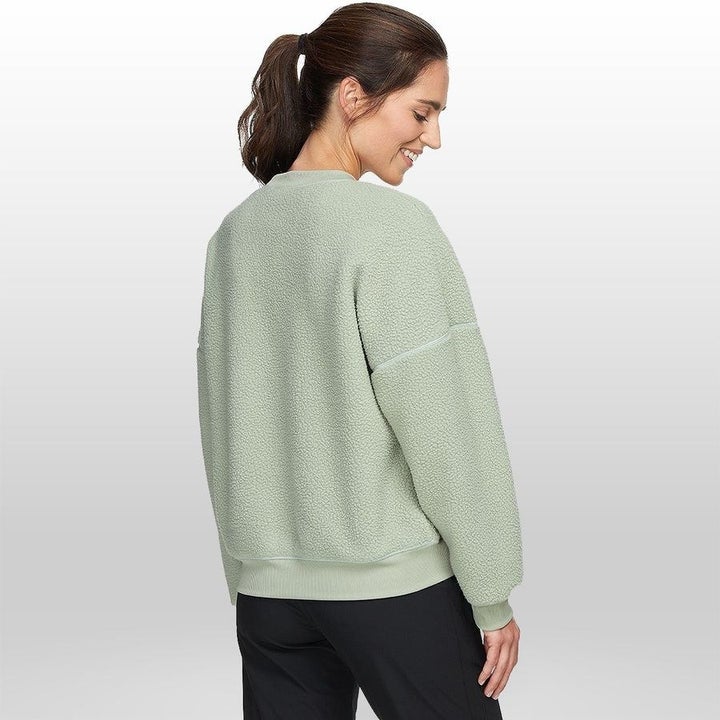 A model in a pale green fleece pullover 