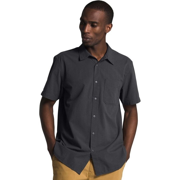 A model in a black short sleeve button up 