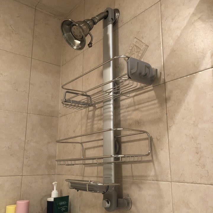 a viralnewsonly editor's photo of the stainless steel over-the-shower-head caddy with two shelves and a soap dish holder