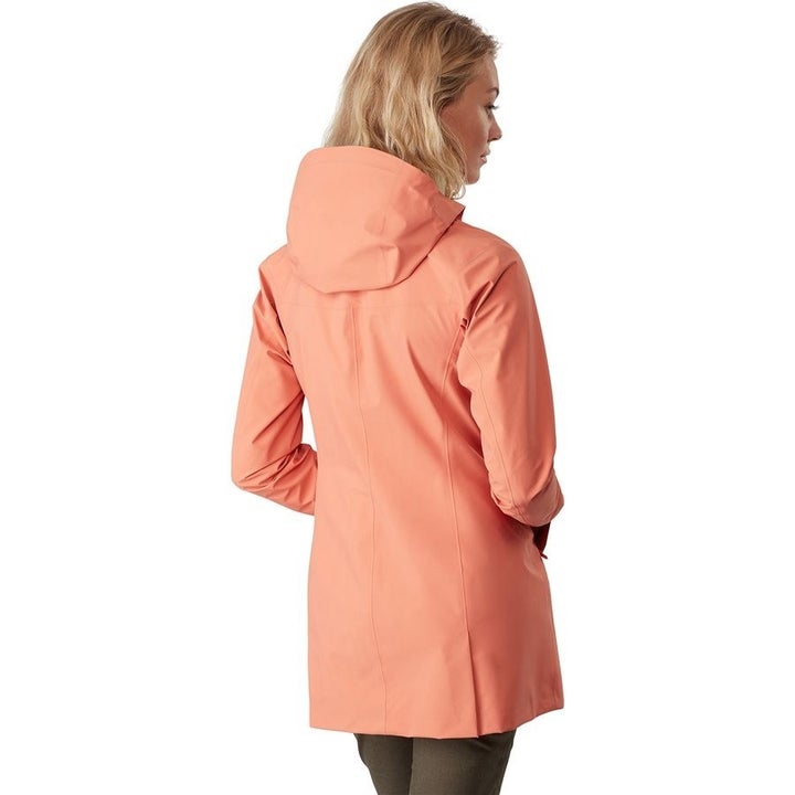 Model showing the back of the coat with large hood and pleats at the bottom 