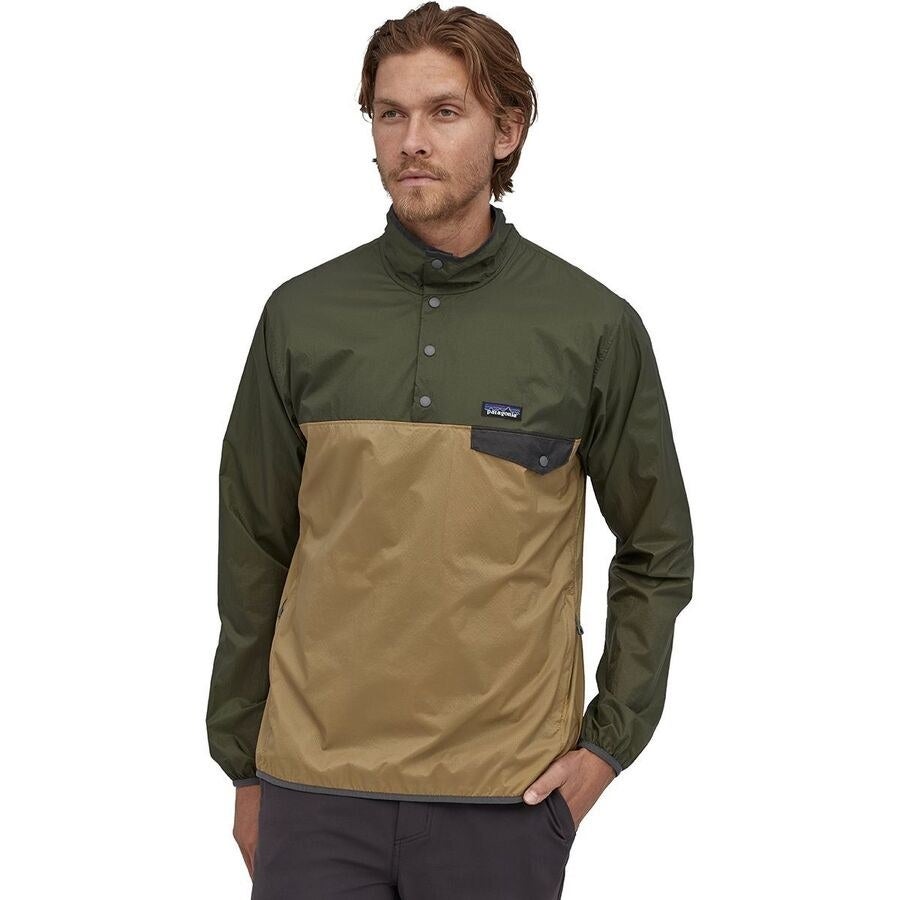 A model in a beige and green color block pullover with a pocket on the left chest 