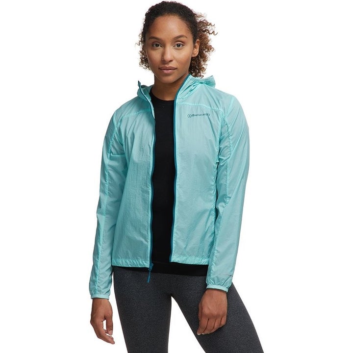 A model in a light blue zippered wind jacket with a hood 