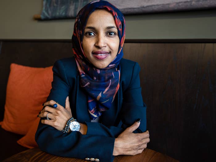 Ilhan Omar sits with arms crossed