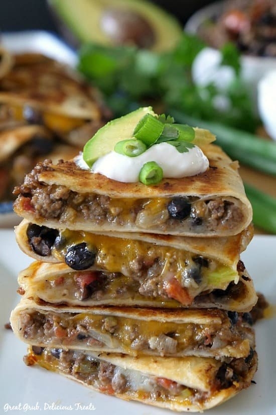 Ground beef quesadilla topped with sour cream and avocado