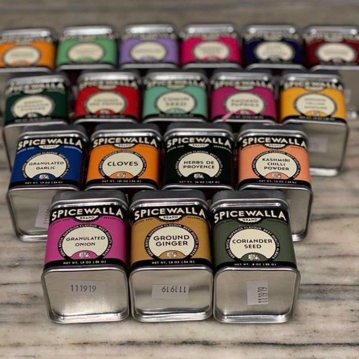 The square tins of spices, each with a different color label