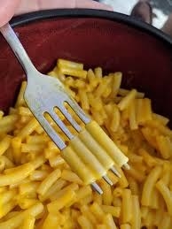 Picture of a fork with a piece of macaroni on each tine 