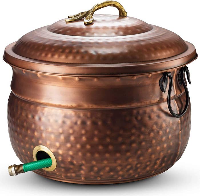 an embossed copper hose pot with a lid