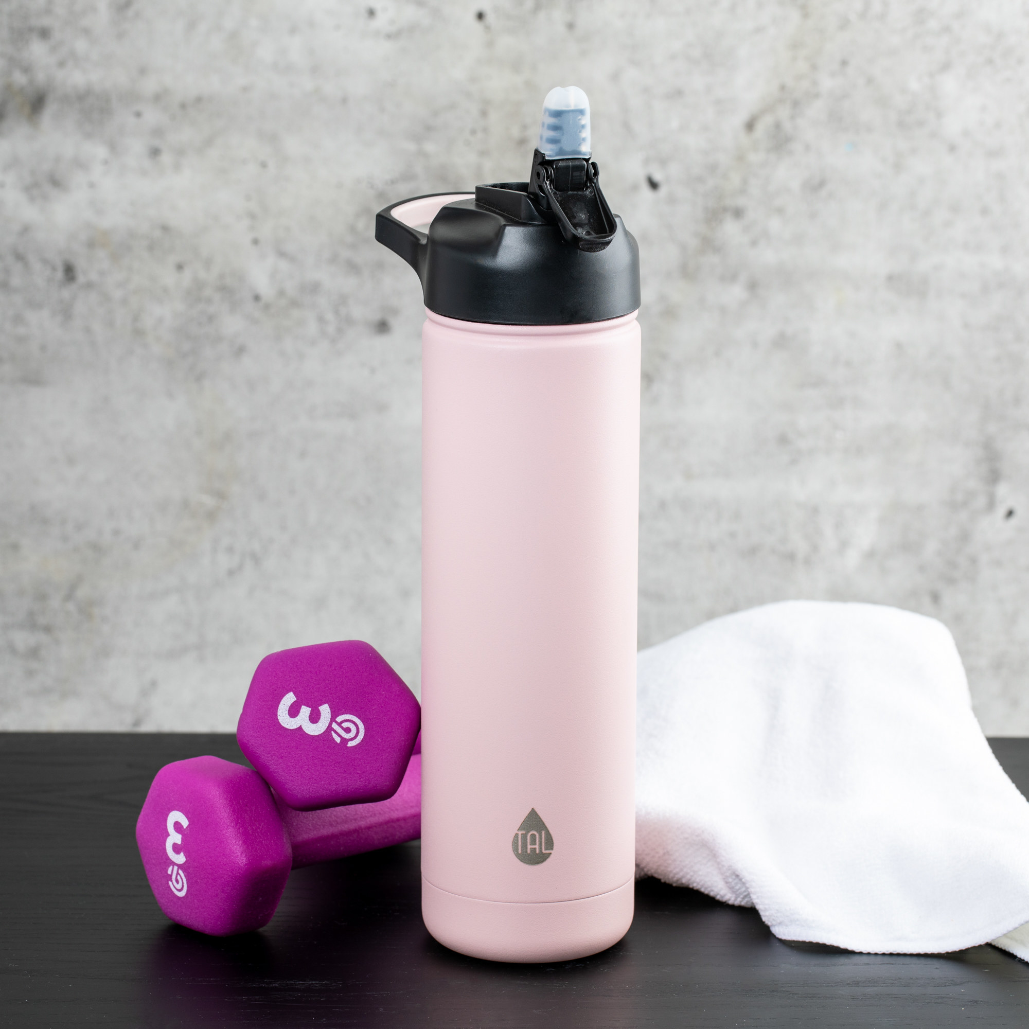 The pale pink reusable water bottle with small straw mouthpiece