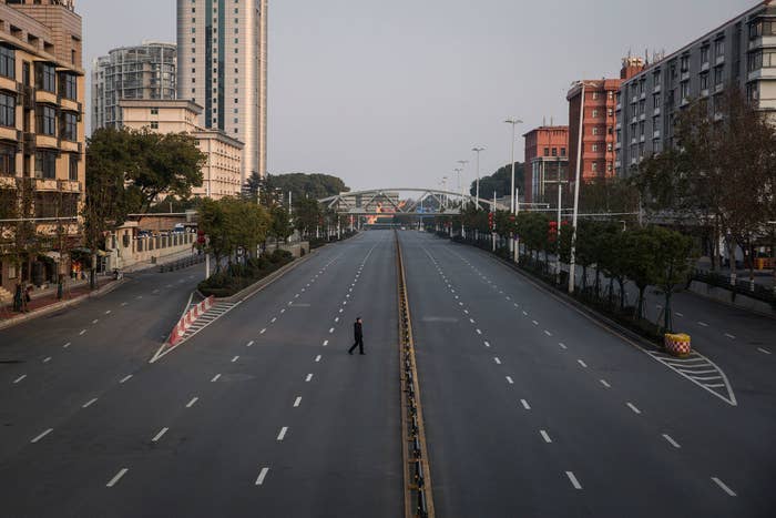 Lone person walking across an empty highway in Wuhan, China