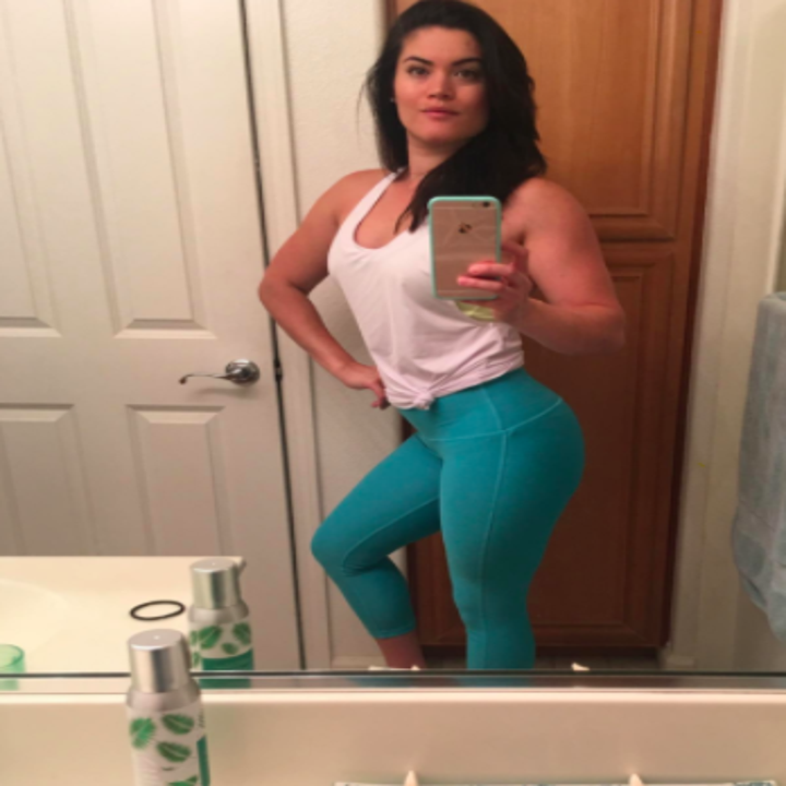 Reviewer wears light blue yoga leggings with a white tank top
