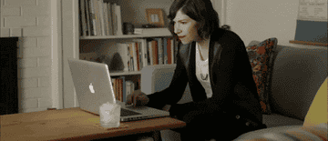 A woman angrily shutting her laptop.