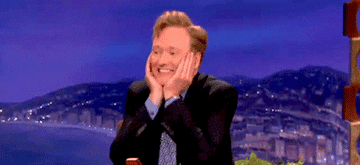 Conan O&#x27;Brien holds his face and wiggles in delight