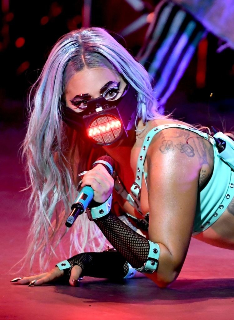 Gaga holding a microphone and wearing a face mask that lights up over the mouthpiece