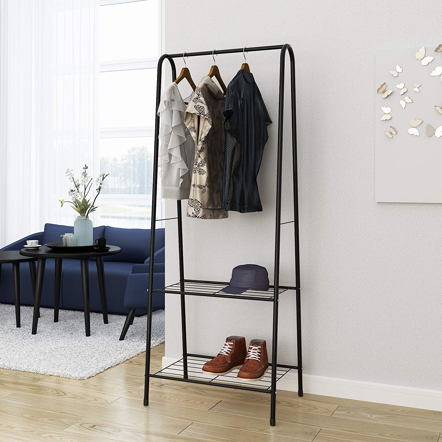 The clothing rack with three shirts, a hat, and a pair of shoes on it