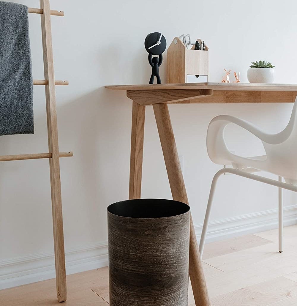 The faux wood trash can next to a desk