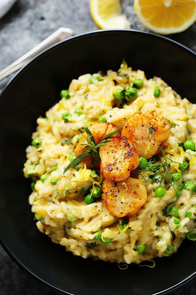 A bowl of creamy sweet pea risotto with scallops and fresh herbs.