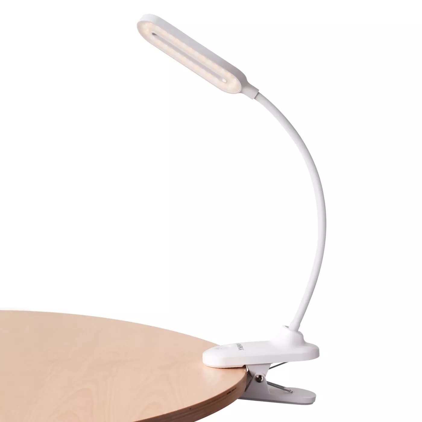 A white desk lamp clamped onto a table