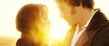 Mr. Darcy leans his head in, allowing his forehead to softly touch Elizabeth&#x27;s, as the sun rises between them in the distance.