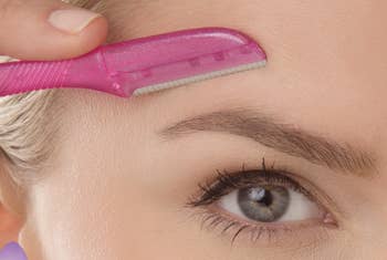 Model shaving hair from above the eyebrows with a tool 