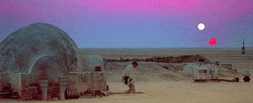 Luke Skywalker exits his home to watch the double sunset.