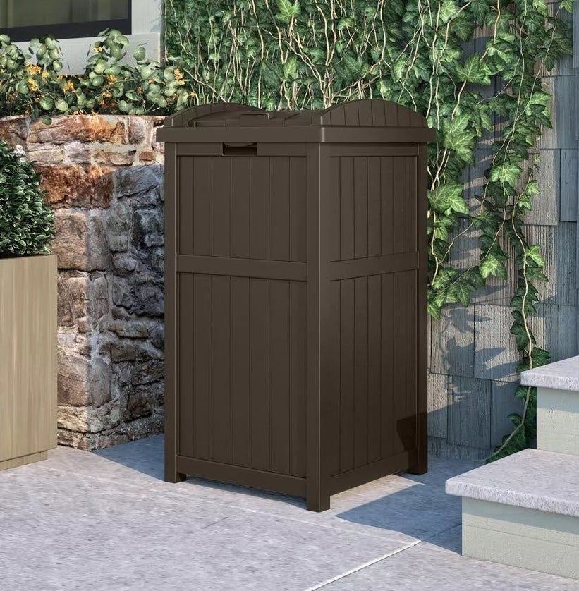 A dark brown, outdoor trash can 