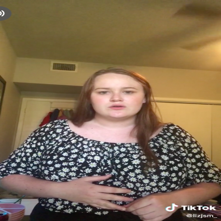 A young woman sings, looking into the camera