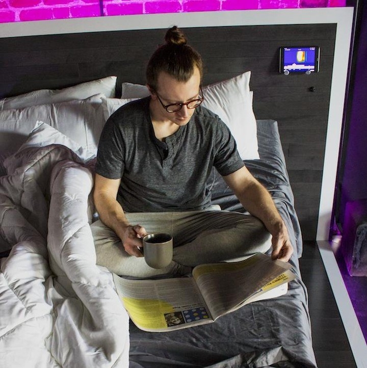 a model reading the paper and drinking coffee in the bed