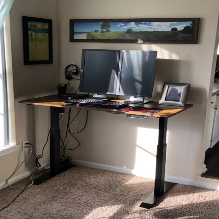 a reviewer photo of the desk with the brown wooden tabletop